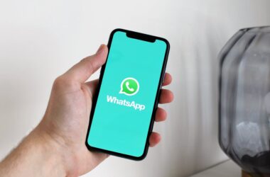 A hand holding a phone with the WhatsApp logo displayed | Photo by Anton from Pexels