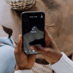 Person opening TikTok on phone | Photo by cottonbro studio