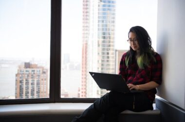 Woman using a laptop by the window | Photo by Christina Morillo