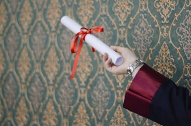 Person holding a diploma | Photo by Gül Işık