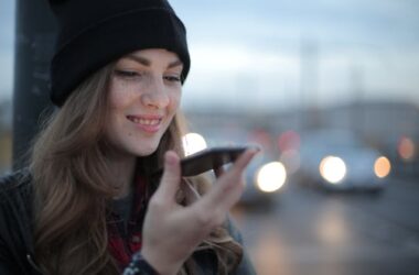 Young woman holding phone | Photo by Andrea Piacquadio