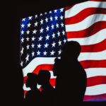 Silhouette of people against the American flag | Photo by Brett Sayles