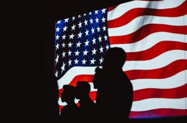 Silhouette of people against the American flag | Photo by Brett Sayles