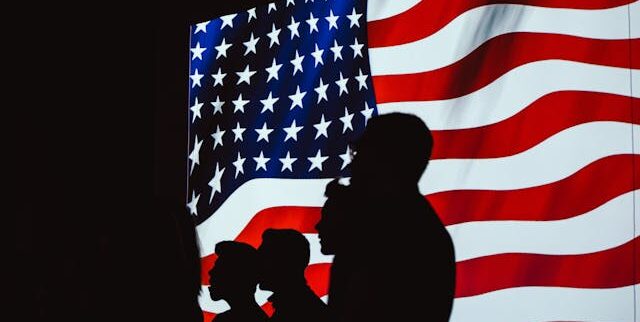 Silhouette of people against the American flag | Photo by Brett Sayles