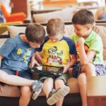 Boys Sitting on Couch Playing on Tablet | Photo by Bulat Khamitov