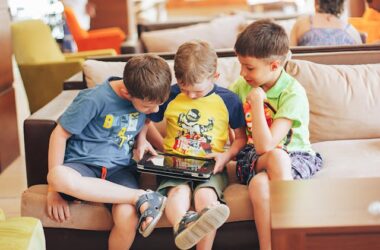 Boys Sitting on Couch Playing on Tablet | Photo by Bulat Khamitov