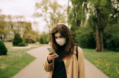 Woman in Brown Coat Holding a Smartphone | Photo by Maksim Goncharenok